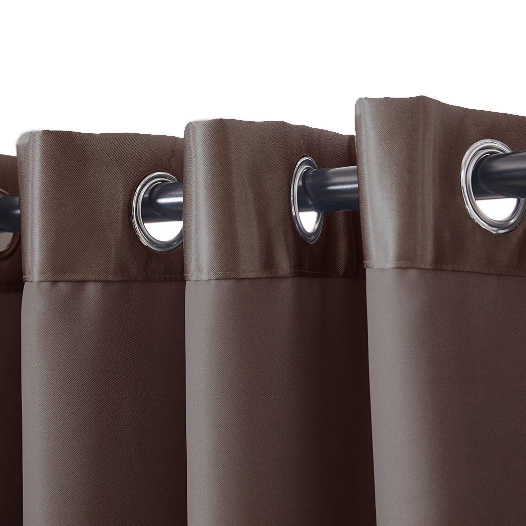 Elegant taupe 2X blockout curtains with eyelet design, providing light and noise blocking for a serene bedroom environment.