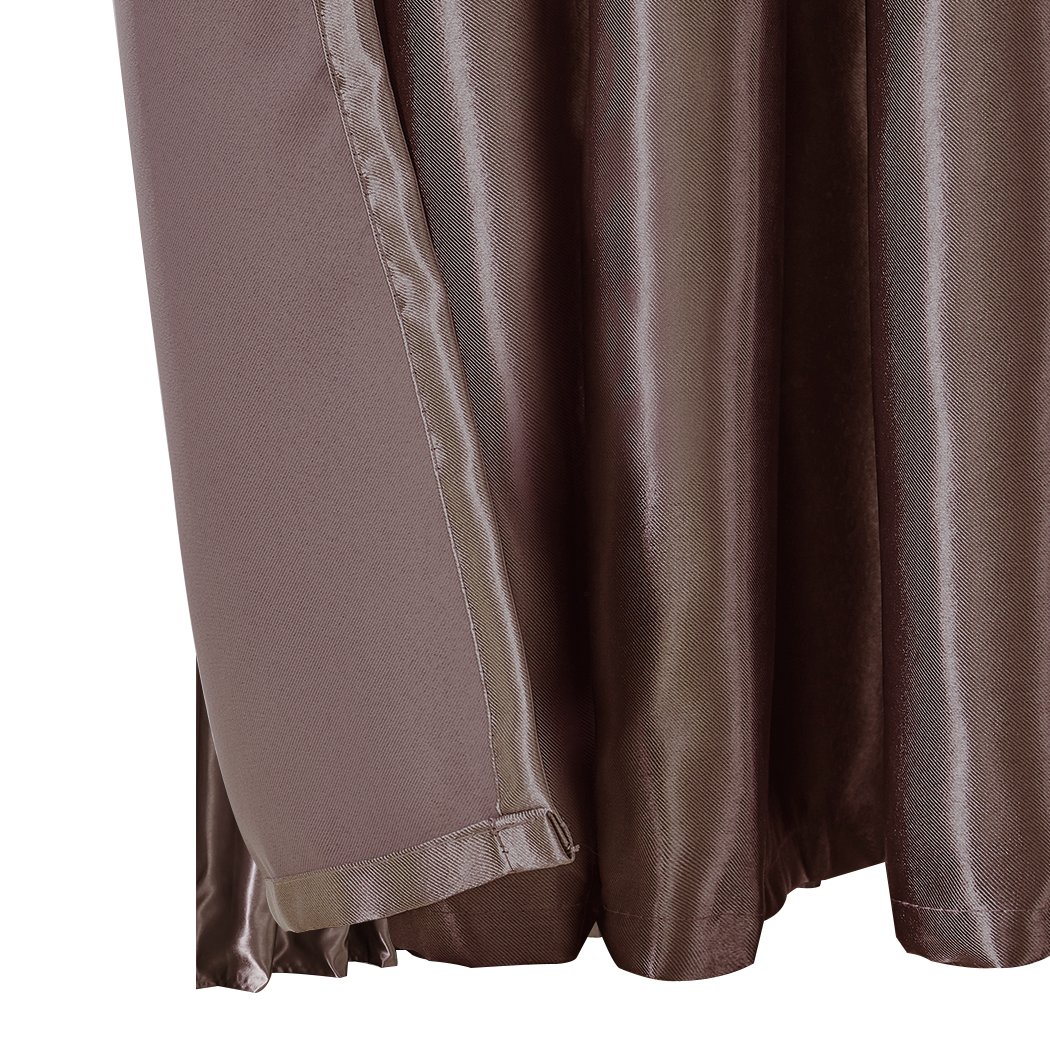 Elegant taupe 2X blockout curtains with eyelet design, providing light and noise blocking for a serene bedroom environment.