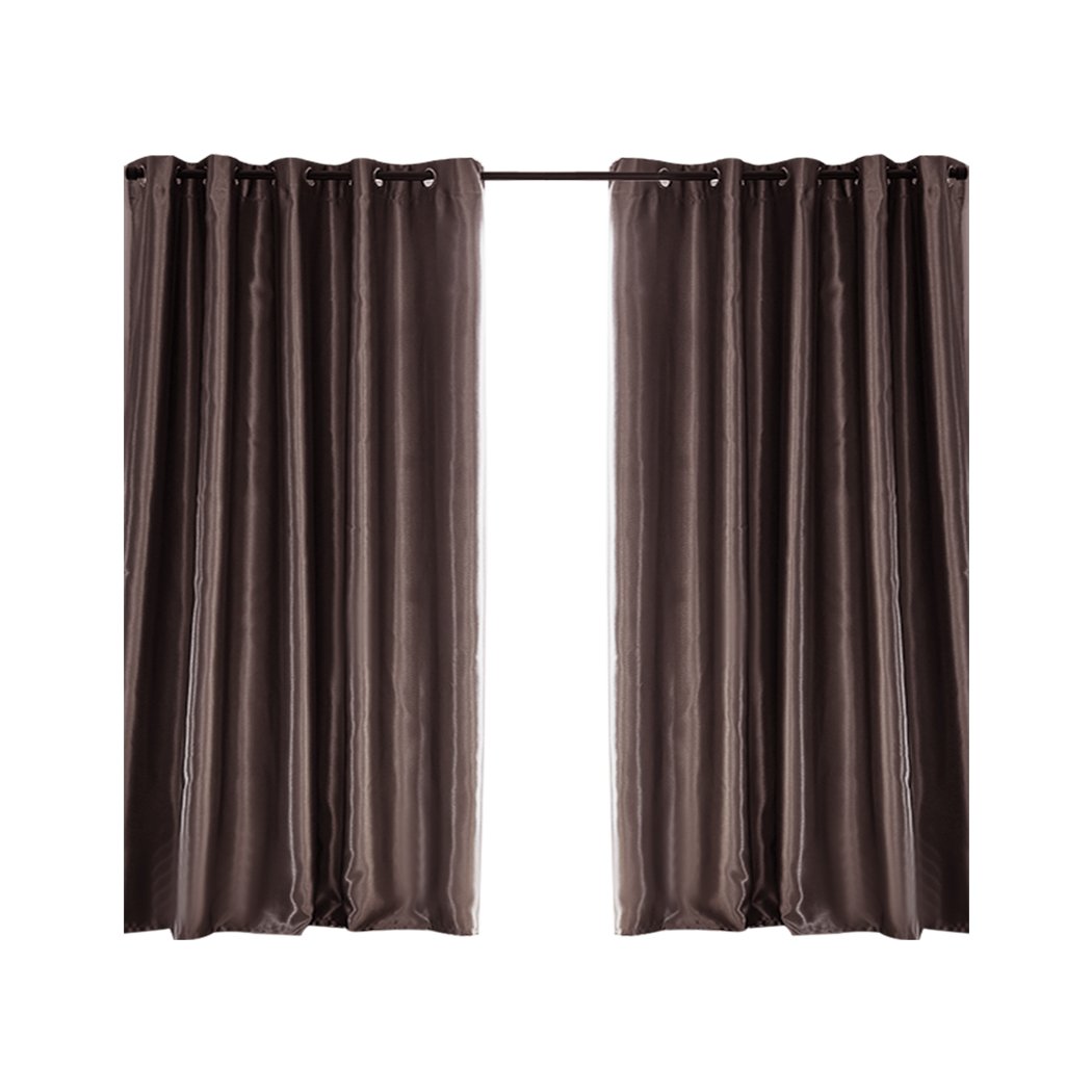 Elegant taupe 2X blockout curtains hanging in a bedroom, showcasing their luxurious texture and design.