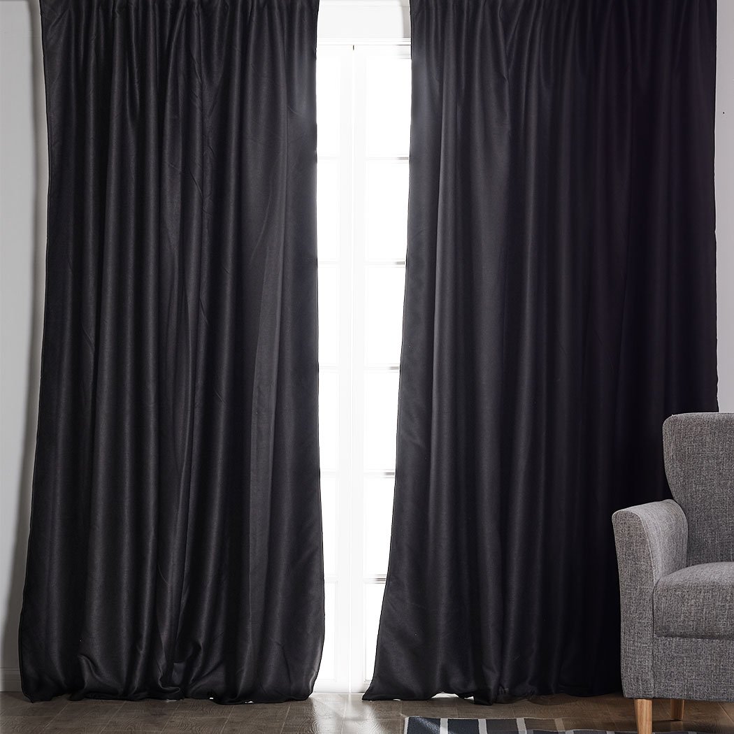 Two dark grey blockout curtains hanging elegantly in a bedroom, showcasing their premium quality and stylish design.
