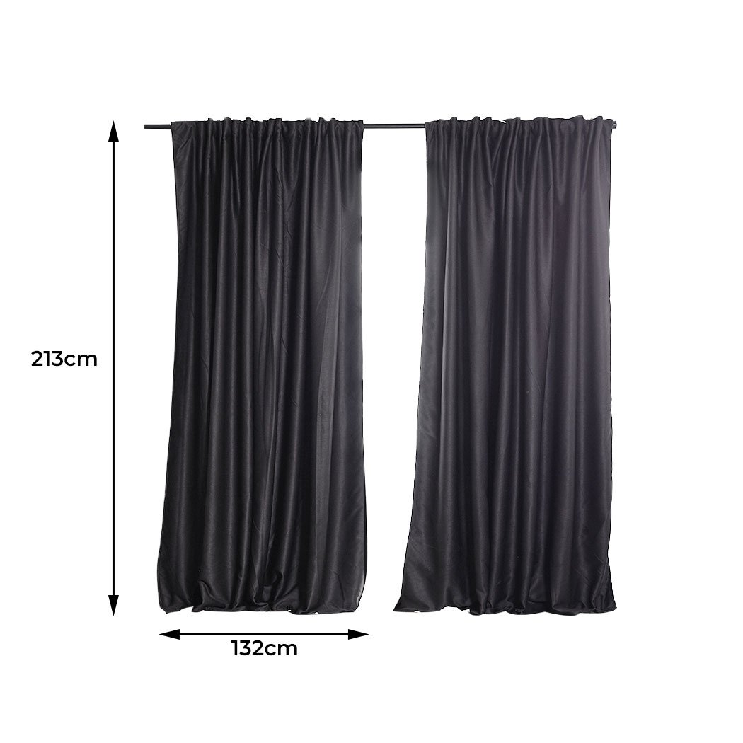 Two dark grey blockout curtains hanging elegantly in a bedroom, showcasing their premium quality and stylish design.