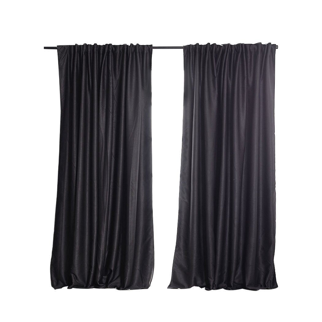 Two dark grey blockout curtains hanging elegantly in a bedroom, showcasing their premium quality and stylish design.