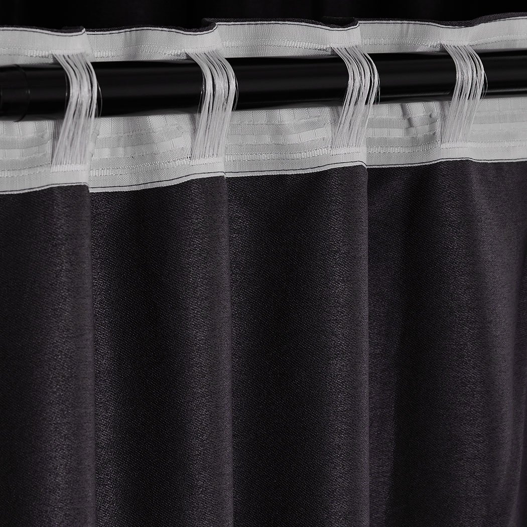 Two dark grey blockout curtains hanging elegantly in a bedroom, showcasing their premium quality and stylish design.