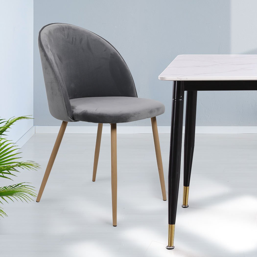 Two elegant grey velvet dining chairs with steel legs, showcasing a French Provincial design, perfect for kitchen or lounge areas.