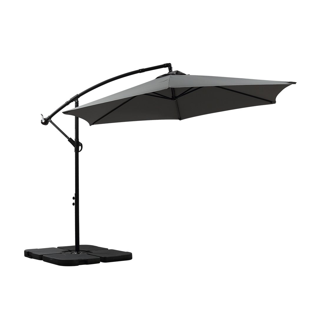 3M Outdoor Umbrella Cantilever Base Stand in a garden setting, showcasing its large grey canopy and sturdy steel frame.