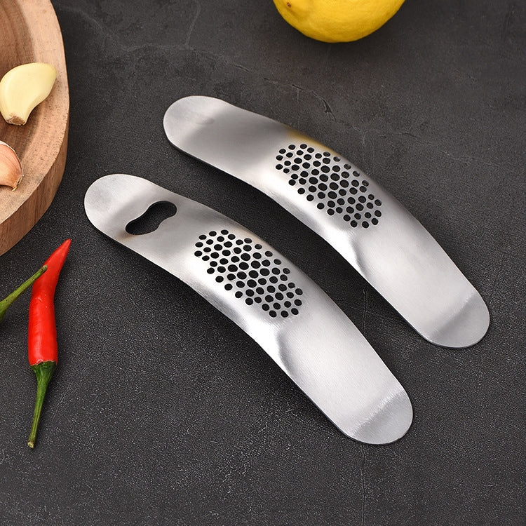 A 430 stainless steel boat shaped garlic grinder, showcasing its sleek design and evenly distributed holes for efficient garlic pressing.