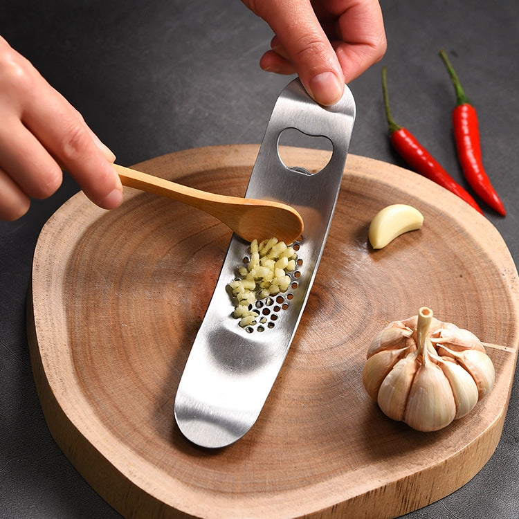 A 430 stainless steel boat shaped garlic grinder, showcasing its sleek design and evenly distributed holes for efficient garlic pressing.