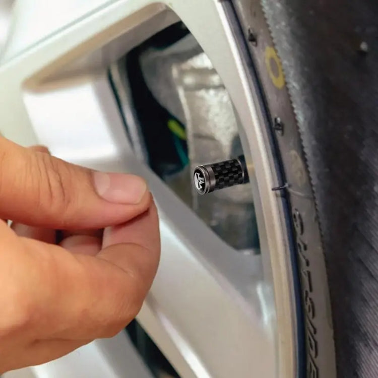 Set of 4 real carbon fibre skeleton tyre valve caps in black, showcasing their sleek design and durable material.