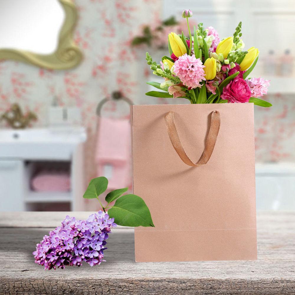 A stack of 50 eco-friendly brown paper bags with twisted handles, ideal for gifts and retail use.