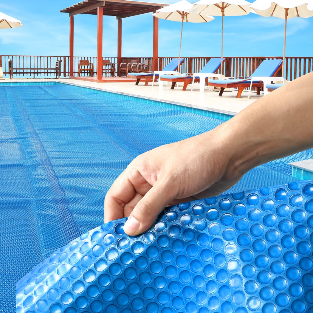 8x4.2M Real 500 Micron Solar Swimming Pool Cover with blue top and silver bottom, designed for durability and efficiency.