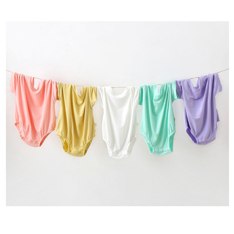 Baby unisex solid color rompers in various colors including pink, blue, green, and yellow, made from soft cotton blend fabric.