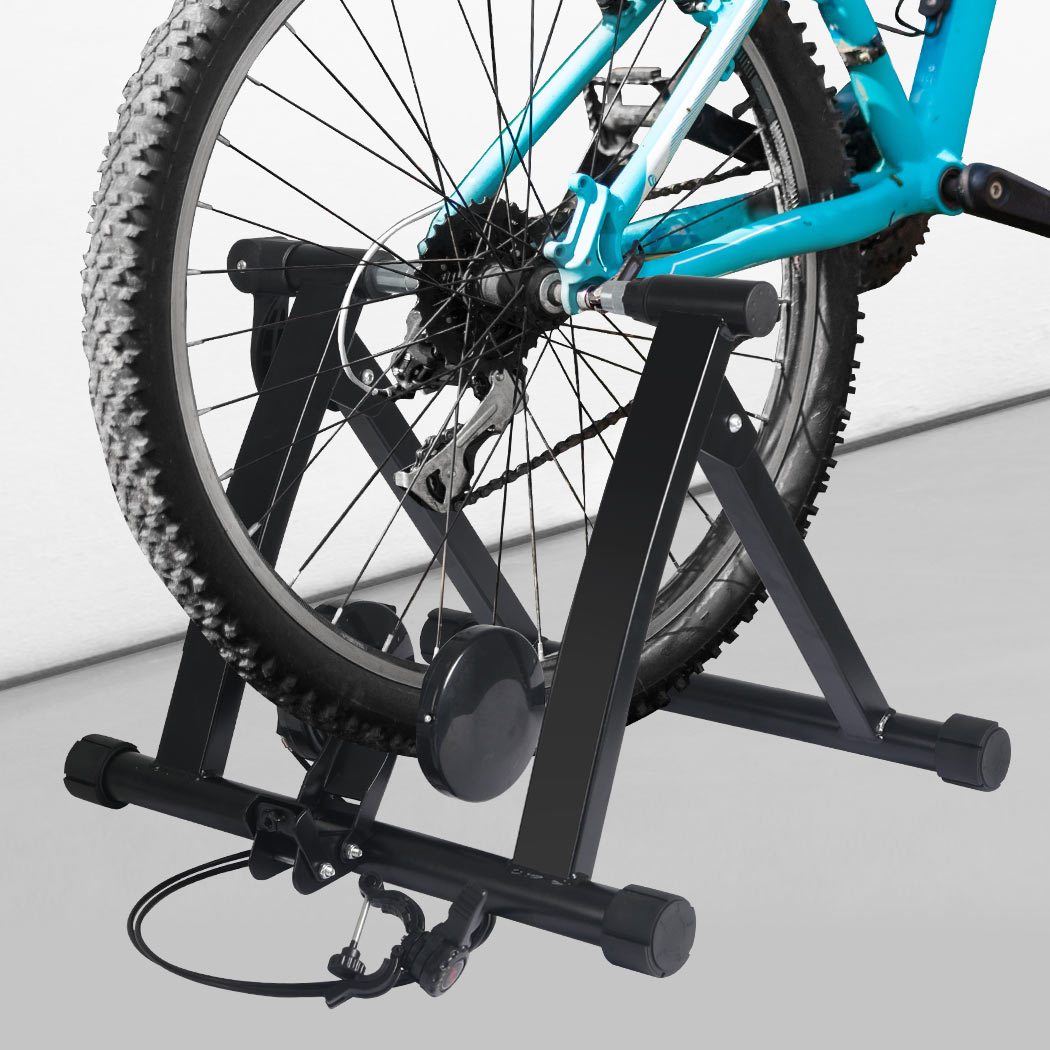 Indoor Bicycle Trainer Stand with heavy-duty steel frame and adjustable footpads, designed for bikes with 26” to 28” wheels.