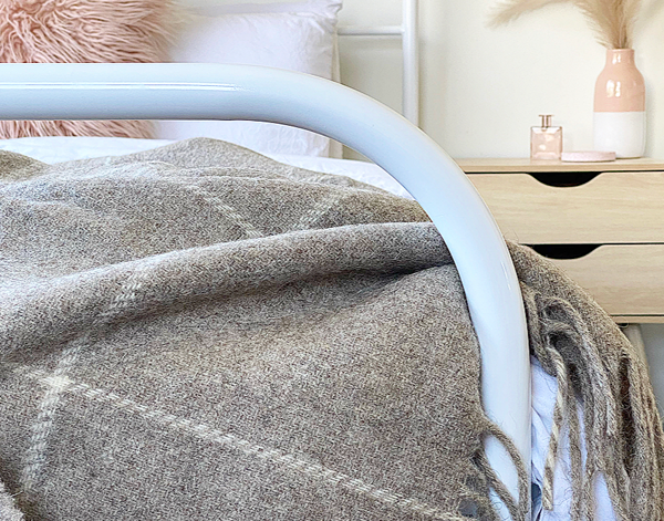 Brighton Throw blanket made from 100% New Zealand wool in a beige striped design, showcasing its soft texture and elegant appearance.