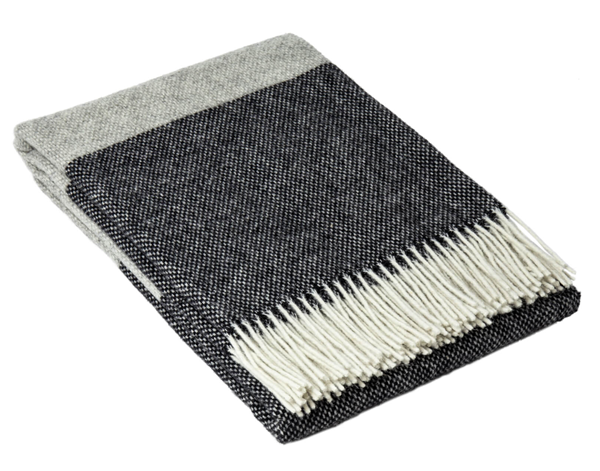 Brighton Throw blanket made from 100% New Zealand wool in a stylish monochrome design, draped elegantly over a sofa.