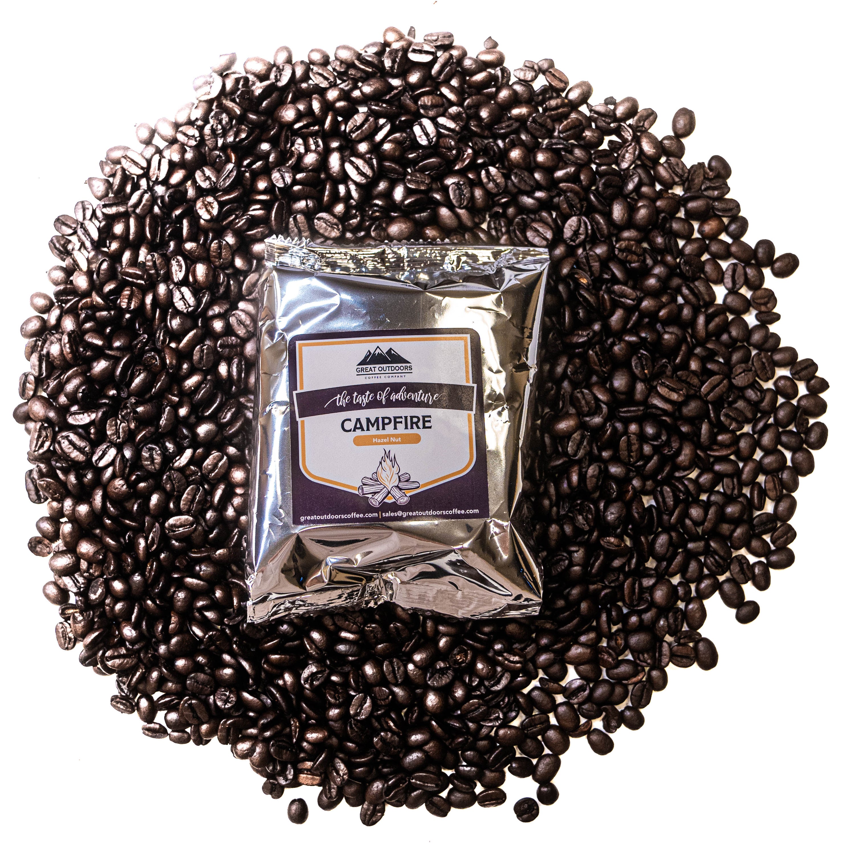 A steaming cup of Campfire Craft Coffee with hazelnut flavor, surrounded by nature, evoking a cozy campfire atmosphere.