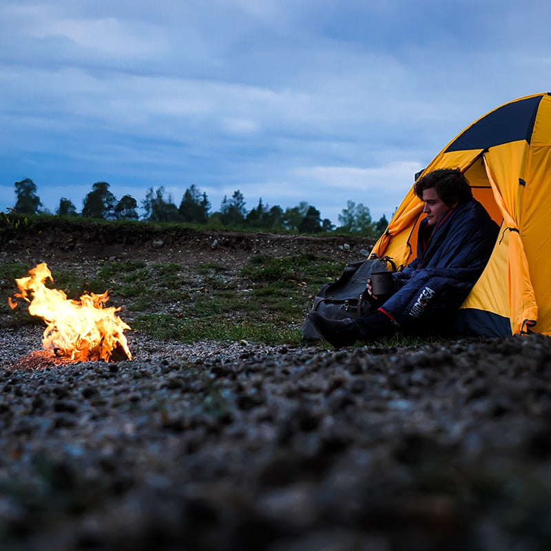 Camping Ultralight Sleeping Bag in a natural outdoor setting, showcasing its waterproof nylon fabric and compact design.