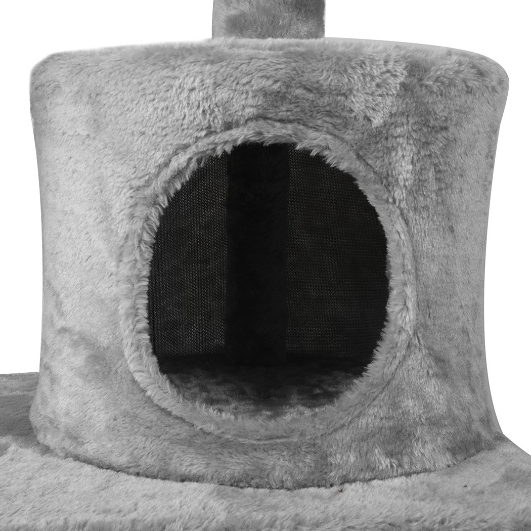 A grey multi-level cat tree tower with plush covering, featuring a scratching post wrapped in sisal and hanging toys for playful cats.