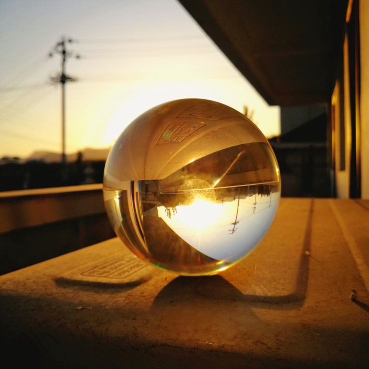 Clear Glass Healing Crystal Ball Sphere on a reflective surface, showcasing its transparent design and perfect for photography props.