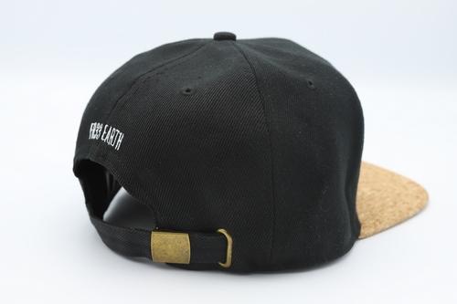Stylish black cork cap with rustic buckle, perfect for sun protection and eco-friendly fashion.