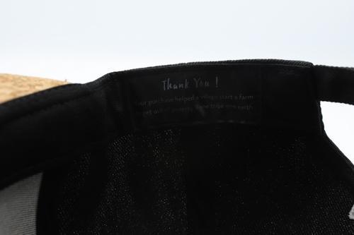 Stylish black cork cap with rustic buckle, perfect for sun protection and eco-friendly fashion.