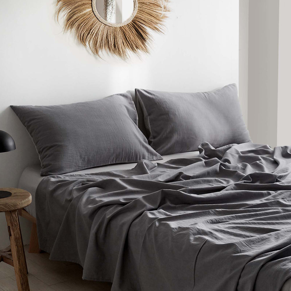 Cosy Club Sheet Set in grey, featuring a flat sheet, fitted sheet, and pillowcase made from 100% washed cotton, showcasing a soft and breathable texture.
