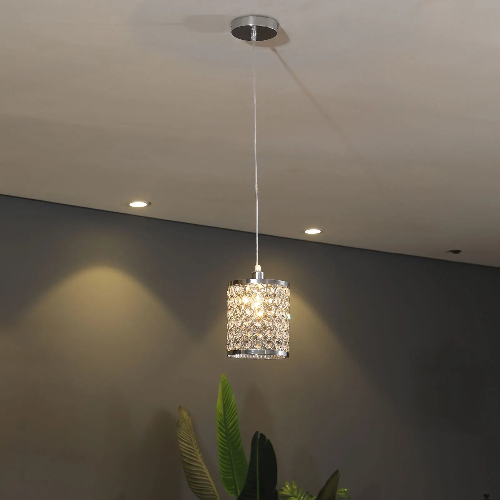 Elegant crystal pendant light with adjustable cord, perfect for modern kitchen islands.