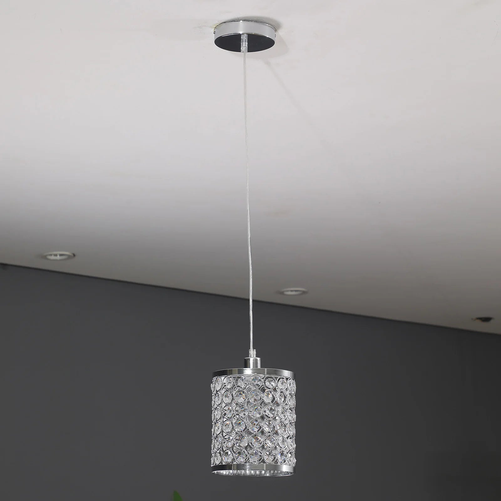 Elegant crystal pendant light with adjustable cord, perfect for modern kitchen islands.