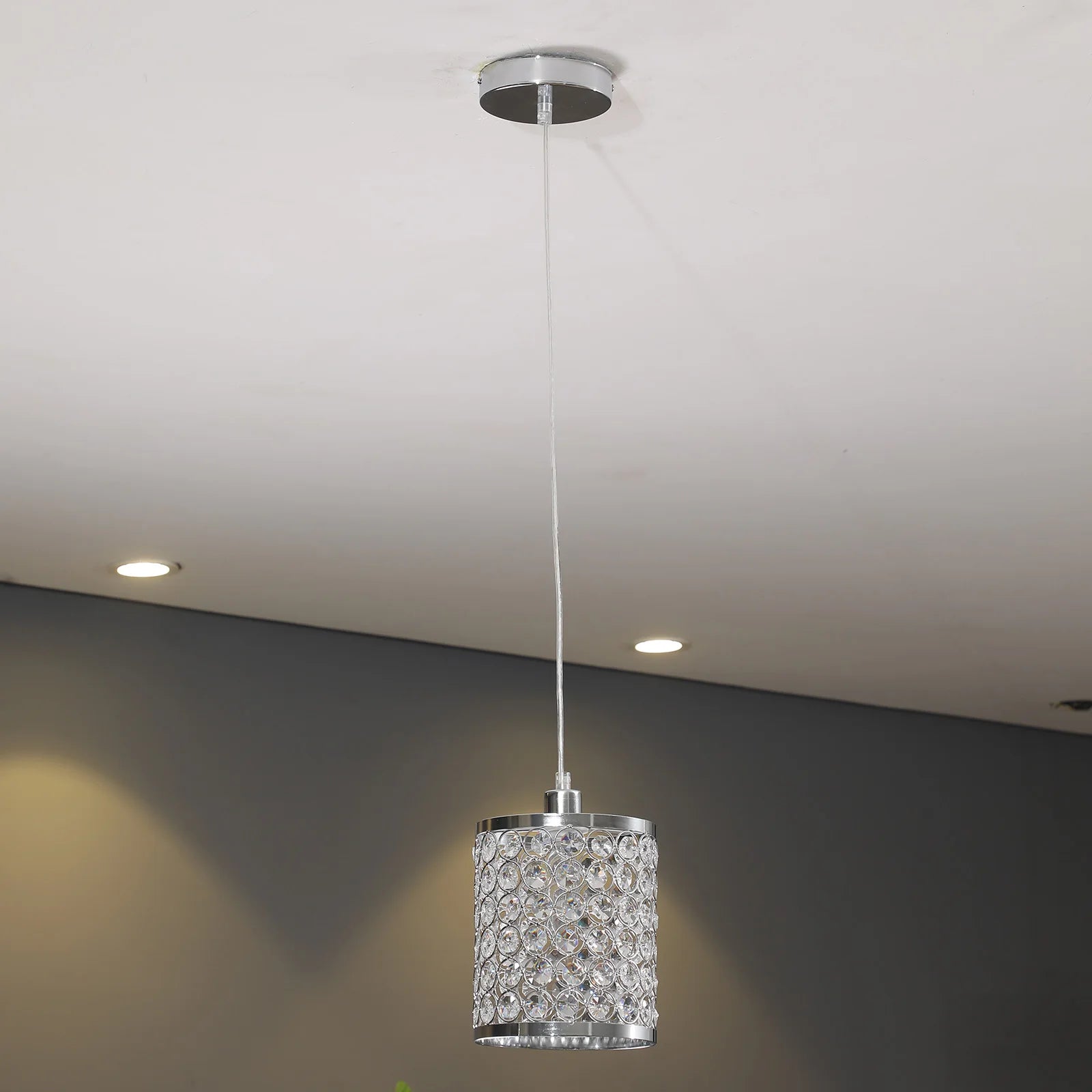 Elegant crystal pendant light with adjustable cord, perfect for modern kitchen islands.