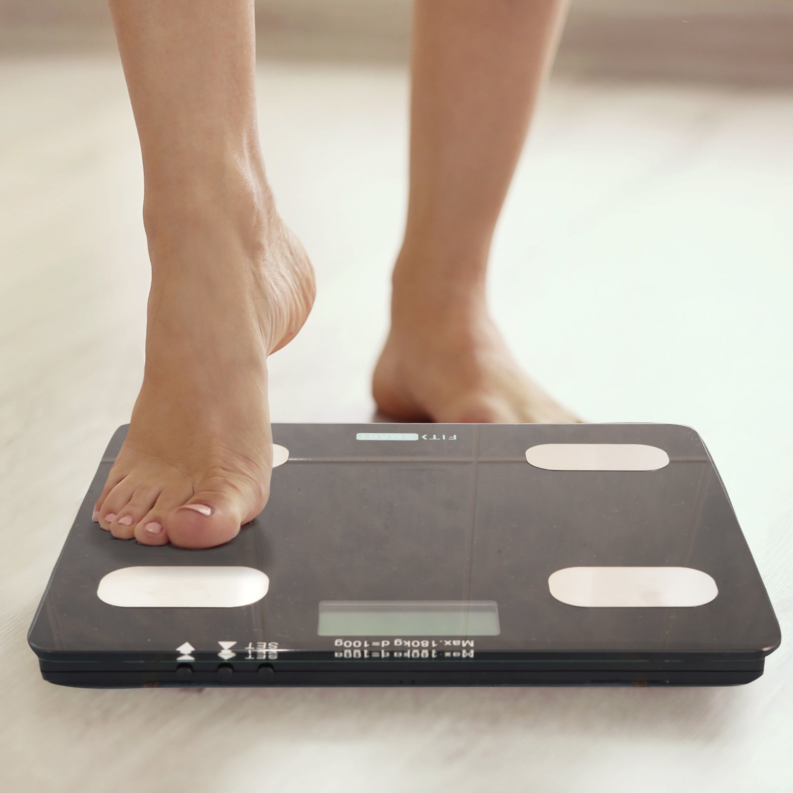 Fit Smart Electronic Floor Body Scale in black with LCD display on a white background, showcasing its sleek tempered glass design.