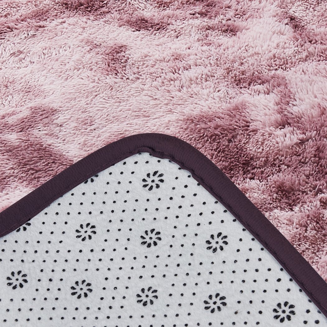 A large, soft shaggy floor rug with a vibrant tie-dyed pattern, showcasing its plush texture and non-slip silicone bottom.