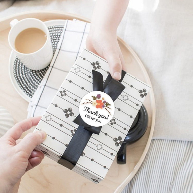 A roll of Flower Hand-decorated Thank You Sealing Stickers featuring floral designs, perfect for gift wrapping and baking.