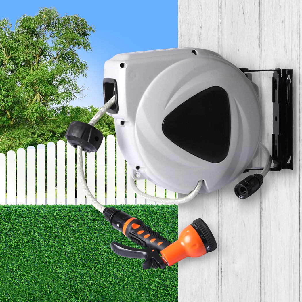 Retractable garden hose reel with spray gun nozzle mounted on a wall, showcasing its compact design and flexibility.