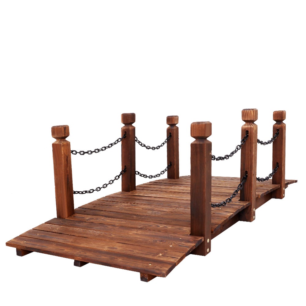 A rustic wooden garden bridge made of burnt fir wood, featuring an arch design and rustic chains along the railings, set in a lush garden landscape.