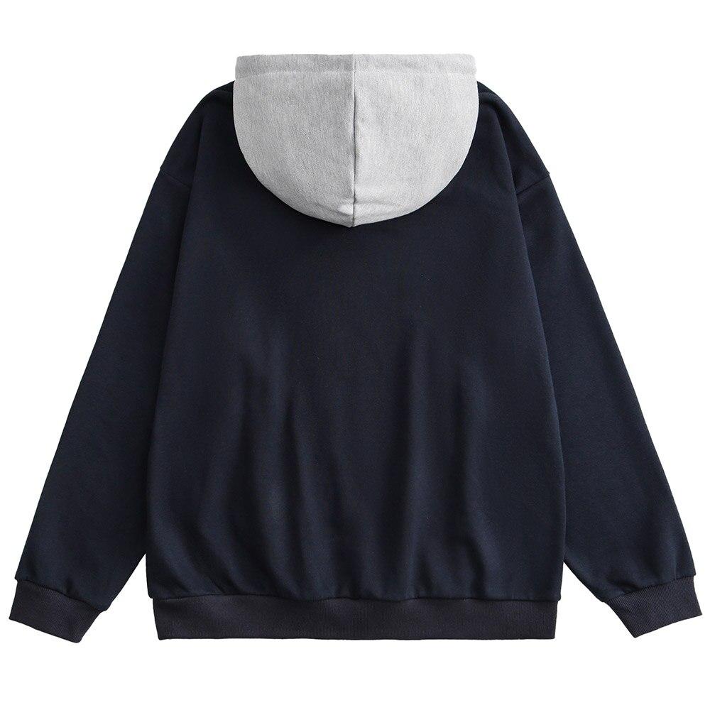 A stylish couple wearing a retro letter print patchwork color hoodie, showcasing a casual autumn streetwear look.