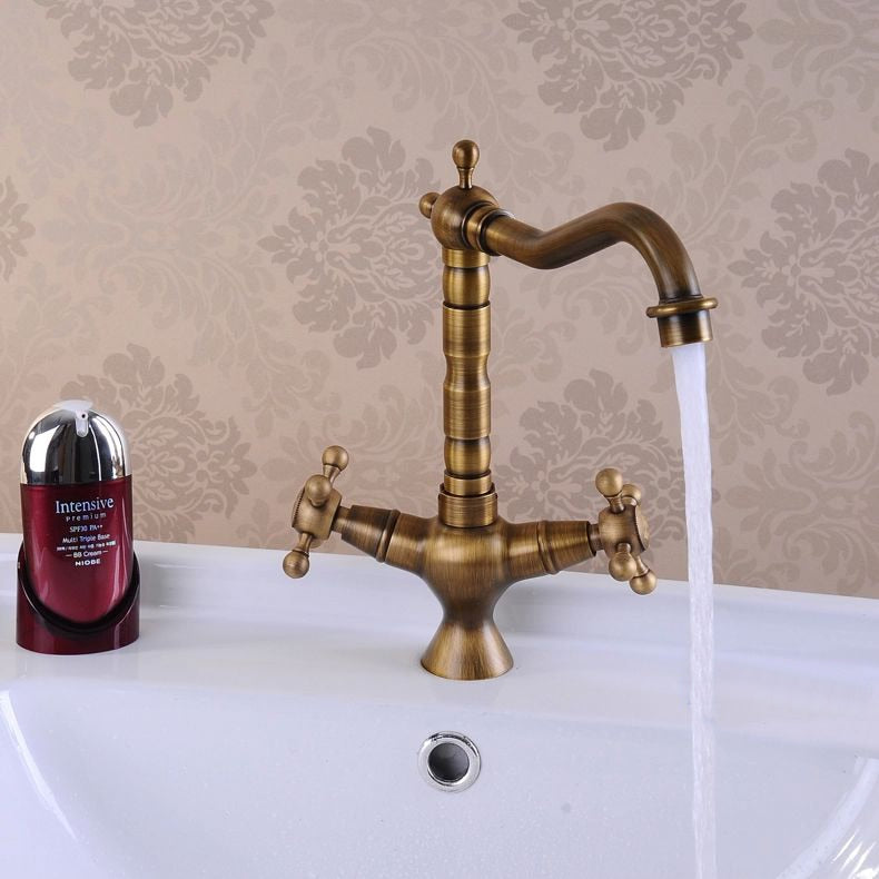 Antique bronze brass kitchen faucet with dual handles and 360-degree rotating spout, showcasing elegant design and durable construction.