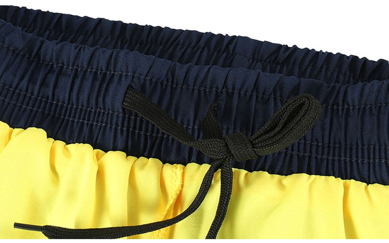 Men's 2 in 1 running shorts featuring quick-dry fabric, zipper pockets, and a stylish patchwork design, ideal for active training.