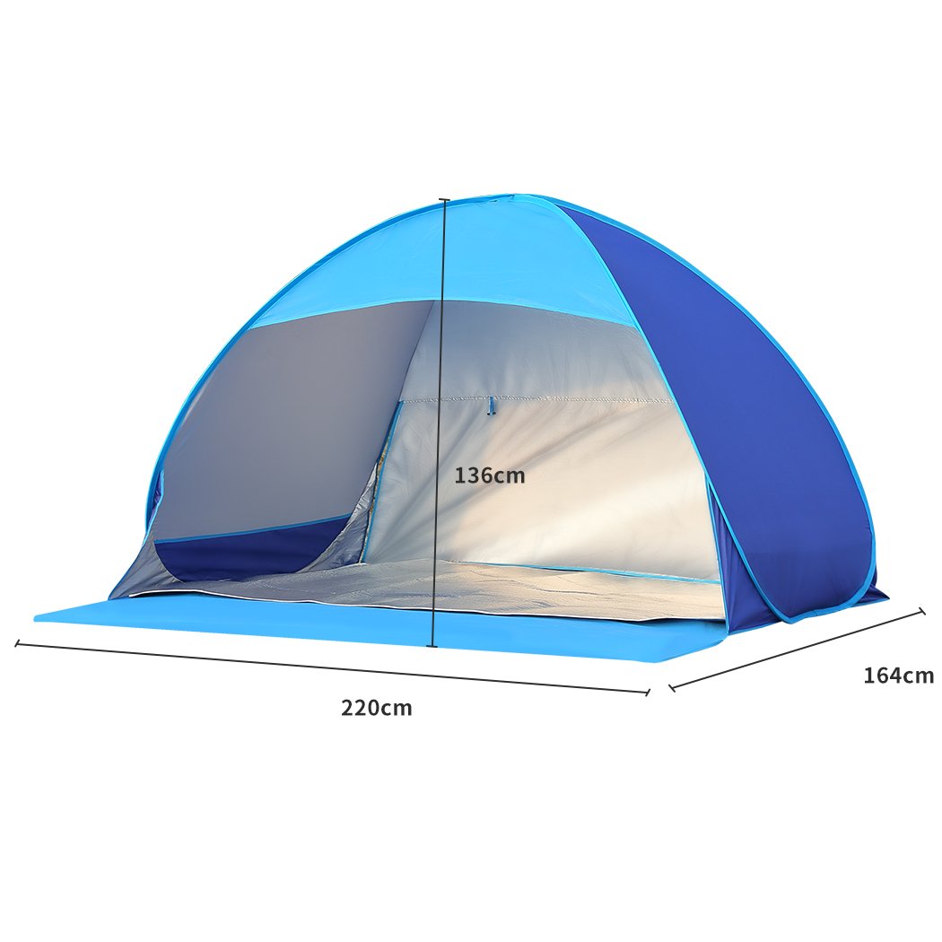 Mountview Pop Up Tent set up on a beach, spacious enough for 2-3 people, featuring a blue color and surrounded by sand and beach scenery.