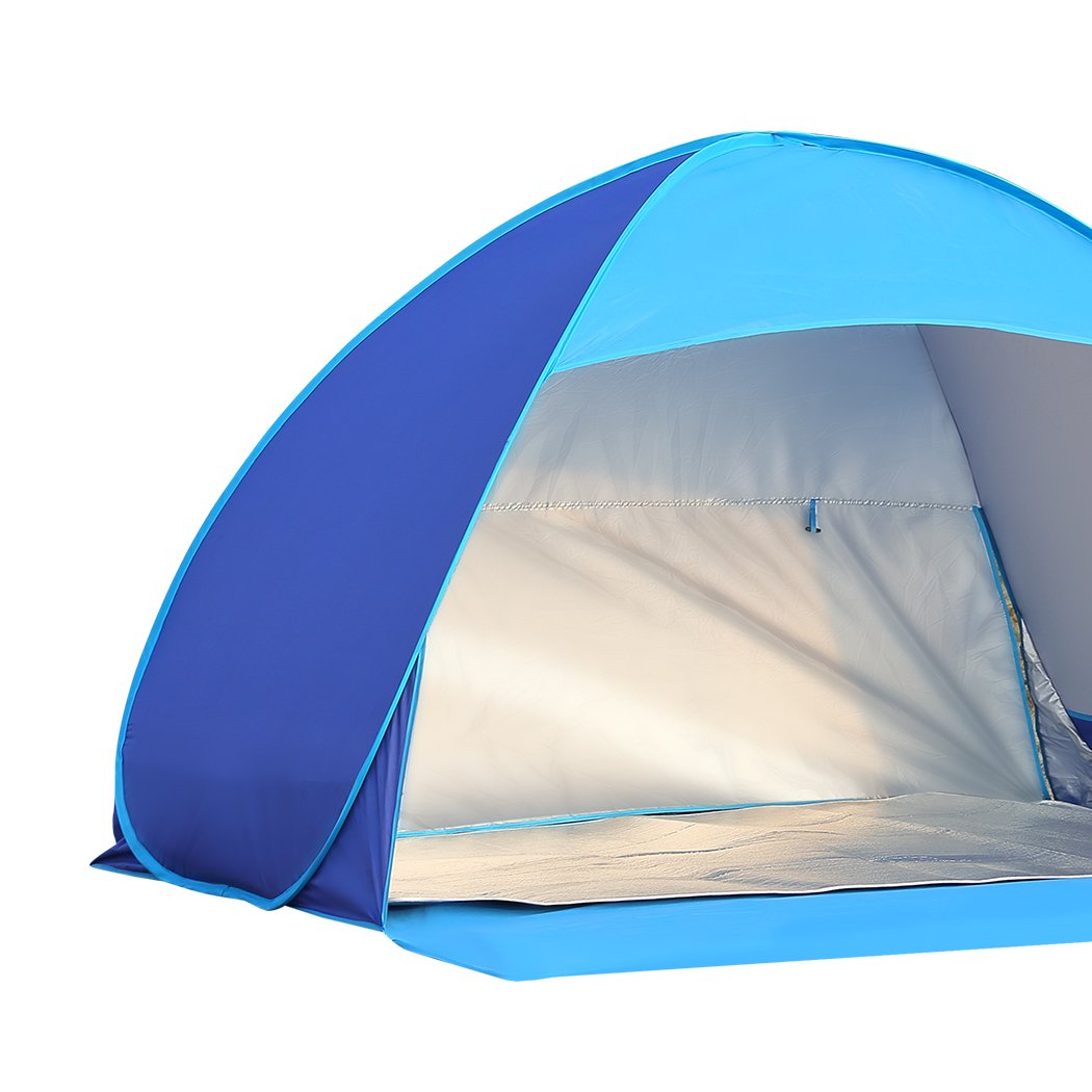 Mountview Pop Up Tent set up on a beach, spacious enough for 2-3 people, featuring a blue color and surrounded by sand and beach scenery.