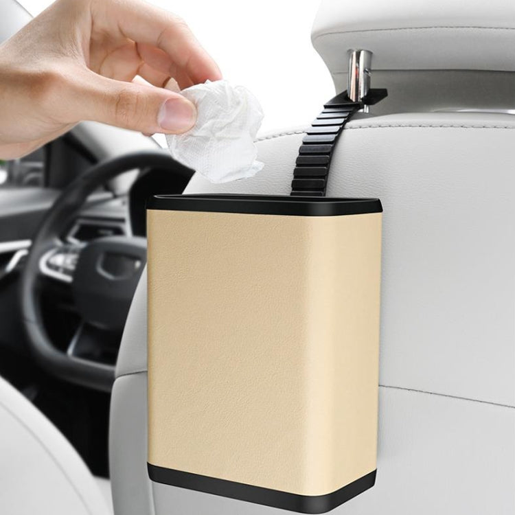 Multifunctional car dustbin hanging on a car seat, made of ABS and leather, designed for storage and waste disposal.