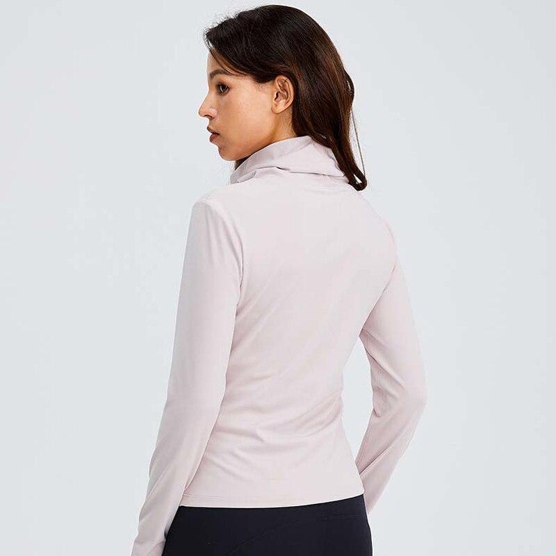 Women wearing a Naked Feel Turtle Neck Yoga Long Sleeve Shirt in a fitness setting, showcasing its stylish design and thumb hole feature.
