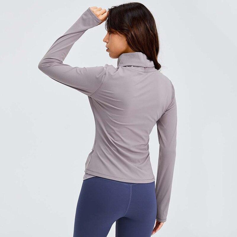 Women wearing a Naked Feel Turtle Neck Yoga Long Sleeve Shirt in a fitness setting, showcasing its stylish design and thumb hole feature.