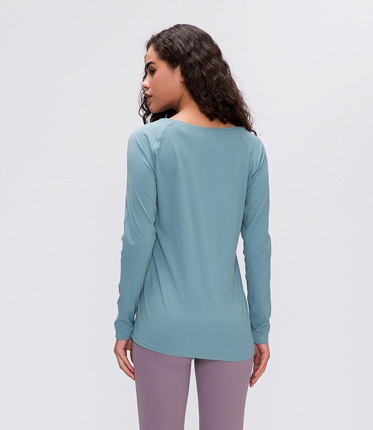 A woman wearing a lightweight, long-sleeved yoga shirt made from naked-feel fabric, ideal for workouts.