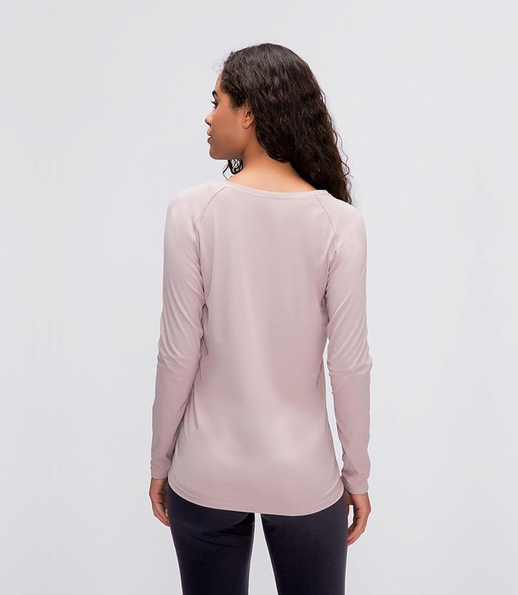 A woman wearing a lightweight, long-sleeved yoga shirt made from naked-feel fabric, ideal for workouts.