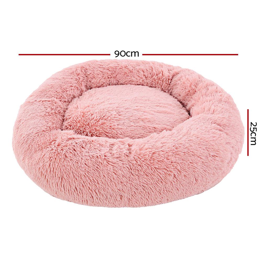 Large pink calming pet bed for dogs and cats, featuring a soft surface, non-slip base, and removable cover for easy cleaning.