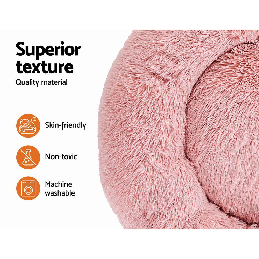 Large pink calming pet bed for dogs and cats, featuring a soft surface, non-slip base, and removable cover for easy cleaning.