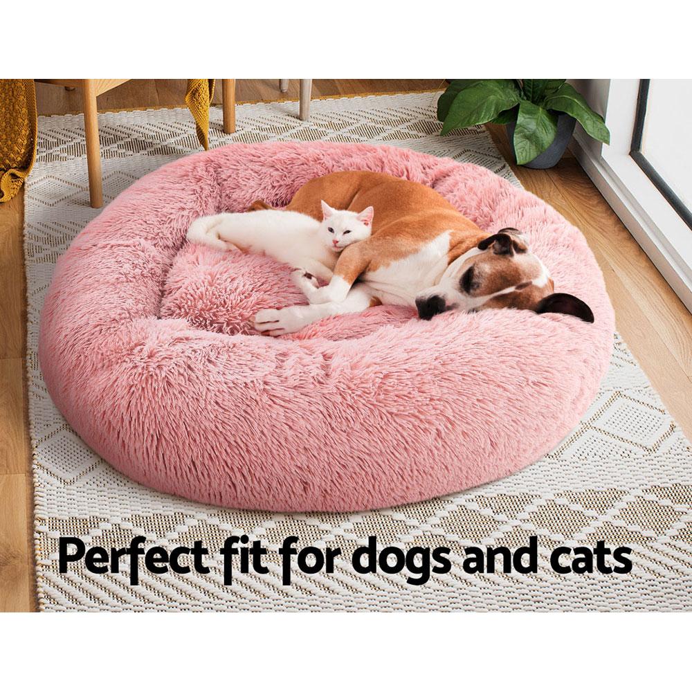 Large pink calming pet bed for dogs and cats, featuring a soft surface, non-slip base, and removable cover for easy cleaning.
