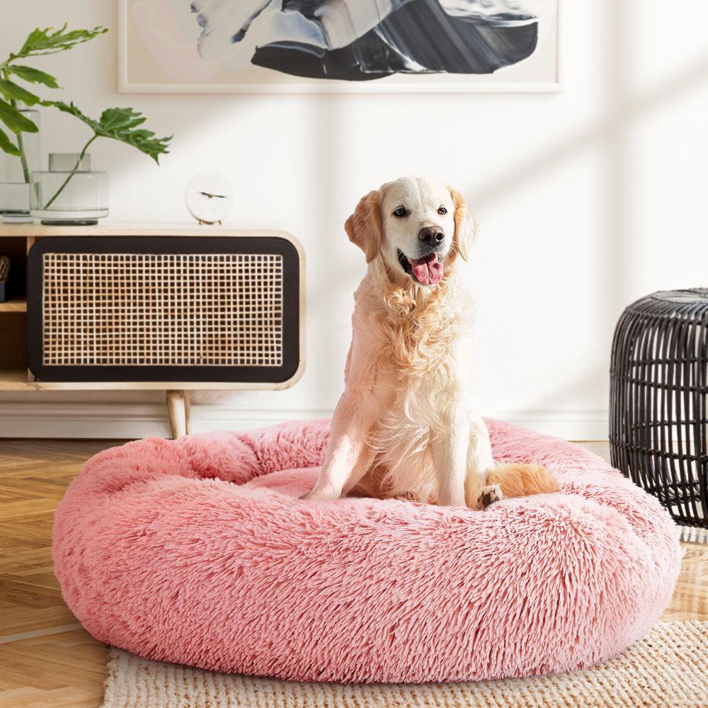 Large pink calming pet bed for dogs and cats, featuring a soft surface, non-slip base, and removable cover for easy cleaning.
