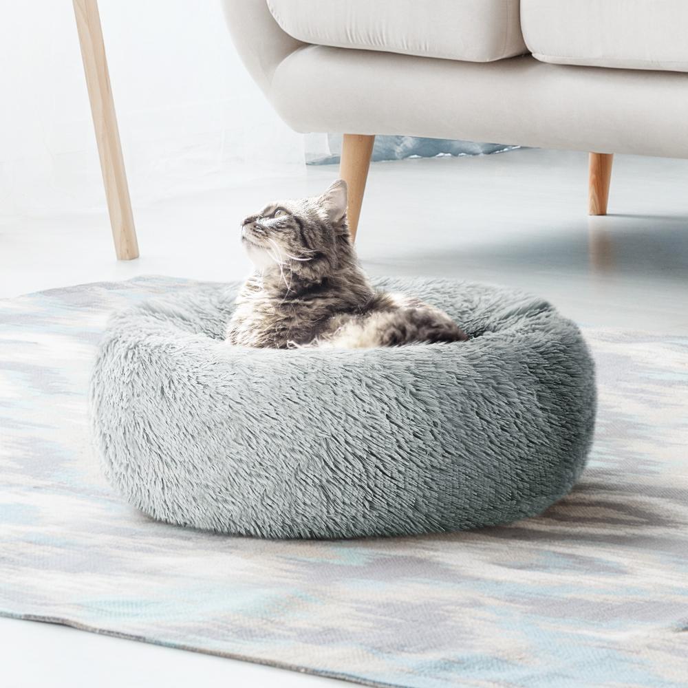 Light grey calming pet bed for small dogs and cats, featuring a soft surface and non-slip base, perfect for cozy sleeping.