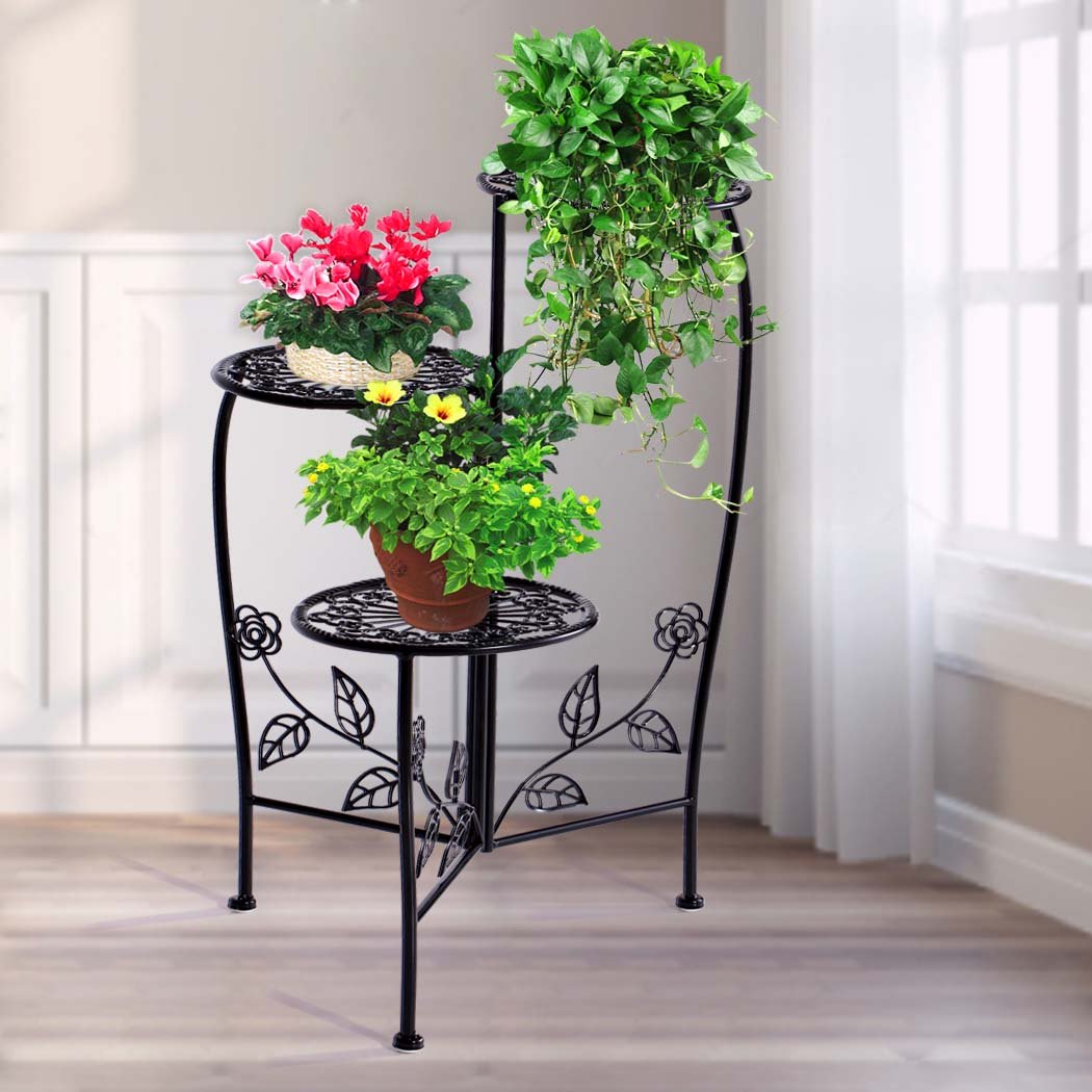 A stylish black metal plant stand with multiple tiers, showcasing various flower pots and greenery, suitable for indoor and outdoor use.