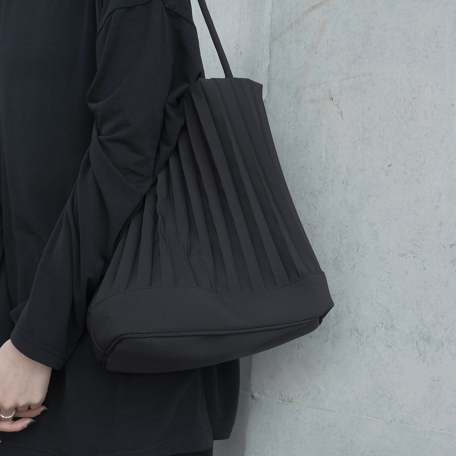 A stylish handmade ruched handbag in black, featuring a bucket shape and adjustable shoulder strap, perfect for various occasions.